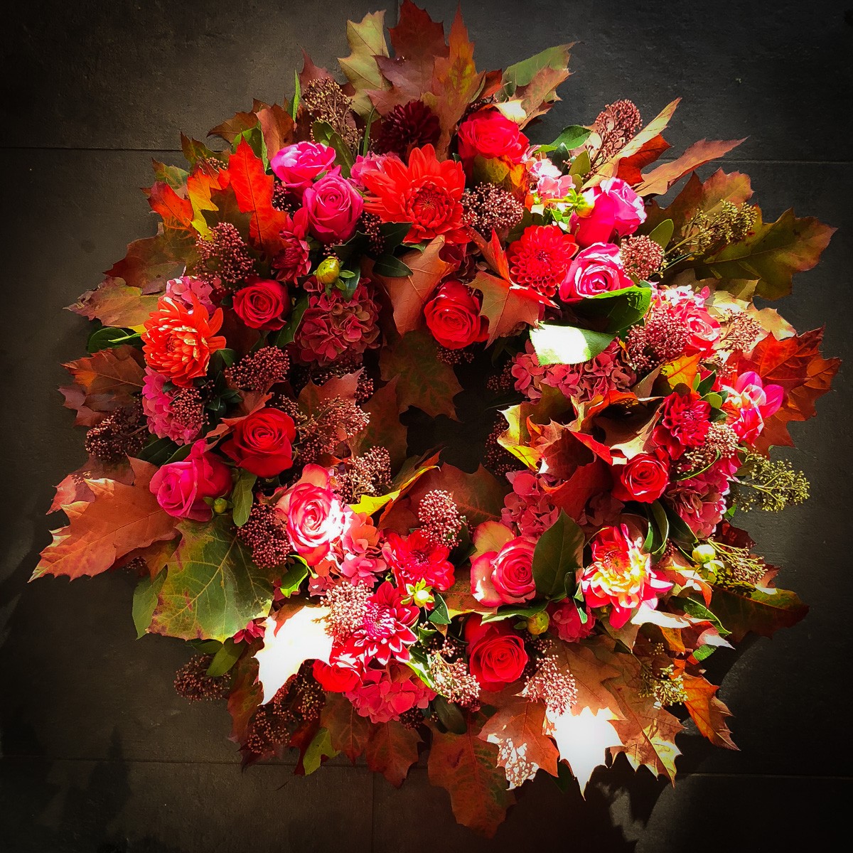 Couronne deuil fleurs rouges orangées couleurs d'automne