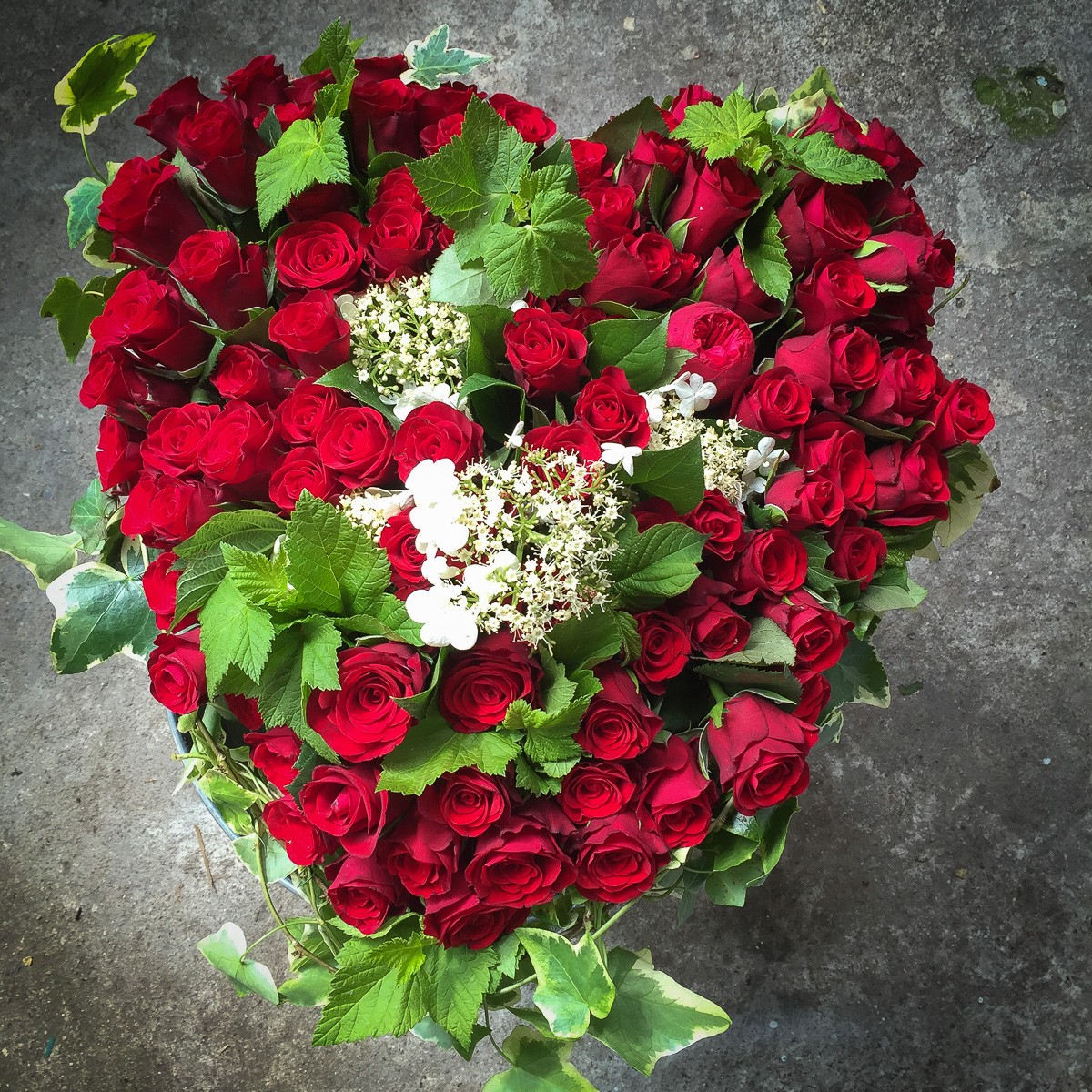 Composition florale roses rouges coussin deuil forme cœur